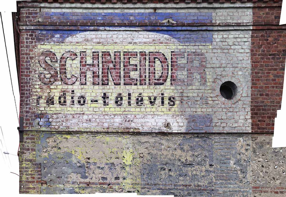 on the wall of this entrance is a raw material wallpaper representing an advertisement of household appliances painted on a brick wall